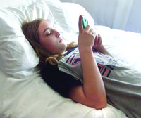 teenage-girl-using-her-cell-phone-in-bed-ZEFU95L.jpg