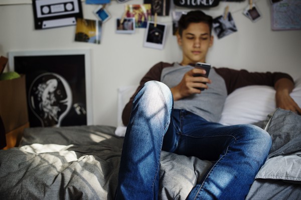 teenage-boy-using-smartphone-in-a-bedroom-social-m-2023-11-27-05-16-42-utc.jpg